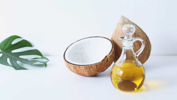 Bottle of hair oil with natural ingredients on a wooden surface