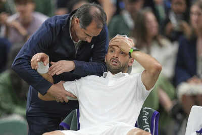 Grigor Dimitrov receives medical attention after injury forces Wimbledon retirement